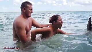 The couple makes love right in the blue waters of the beach
