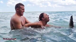 The couple makes love right in the blue waters of the beach