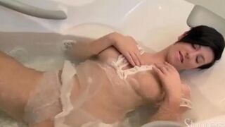 A lonely brunette woman caresses herself under the shower head