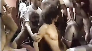 A girl in sexy stockings is having fun with a group of guys