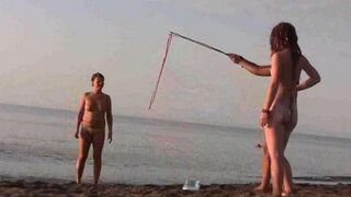 A girl is having fun naked on the beach, showcasing her body