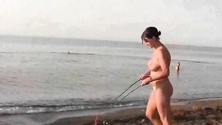A girl is having fun naked on the beach, showcasing her body