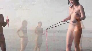 A girl is having fun naked on the beach, showcasing her body