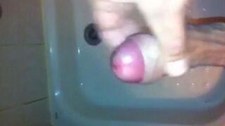 The kid caresses his cock with his hand in the shower stream