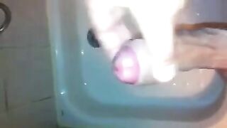 The kid caresses his cock with his hand in the shower stream