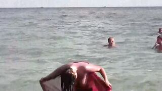 A hot naked girl is bathing in the sea