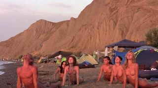 A group of naked people play volleyball on the nude beach