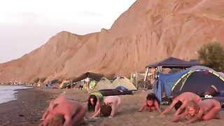 A group of naked people play volleyball on the nude beach
